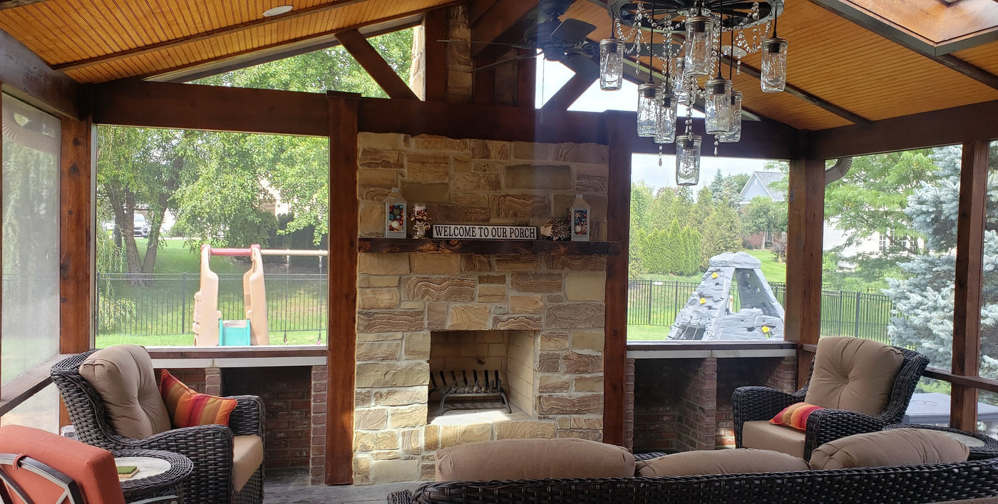 Covered outdoor living space with stone fireplace