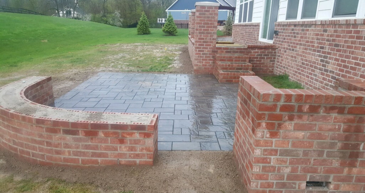 Curved brick seat wall beside a paver patio