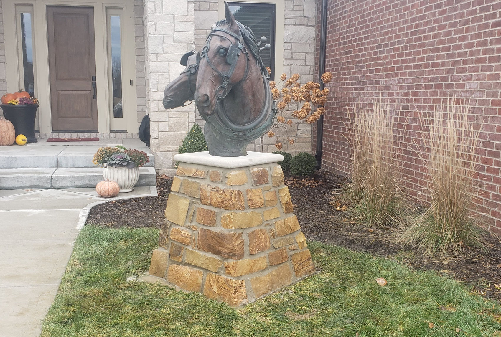 Cut-stone pillar with bronze sculpture